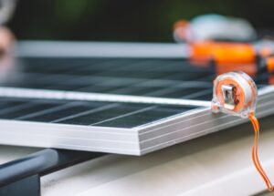 Panneau solaire en installation avec ruban à mesurer en arrière-plan.
