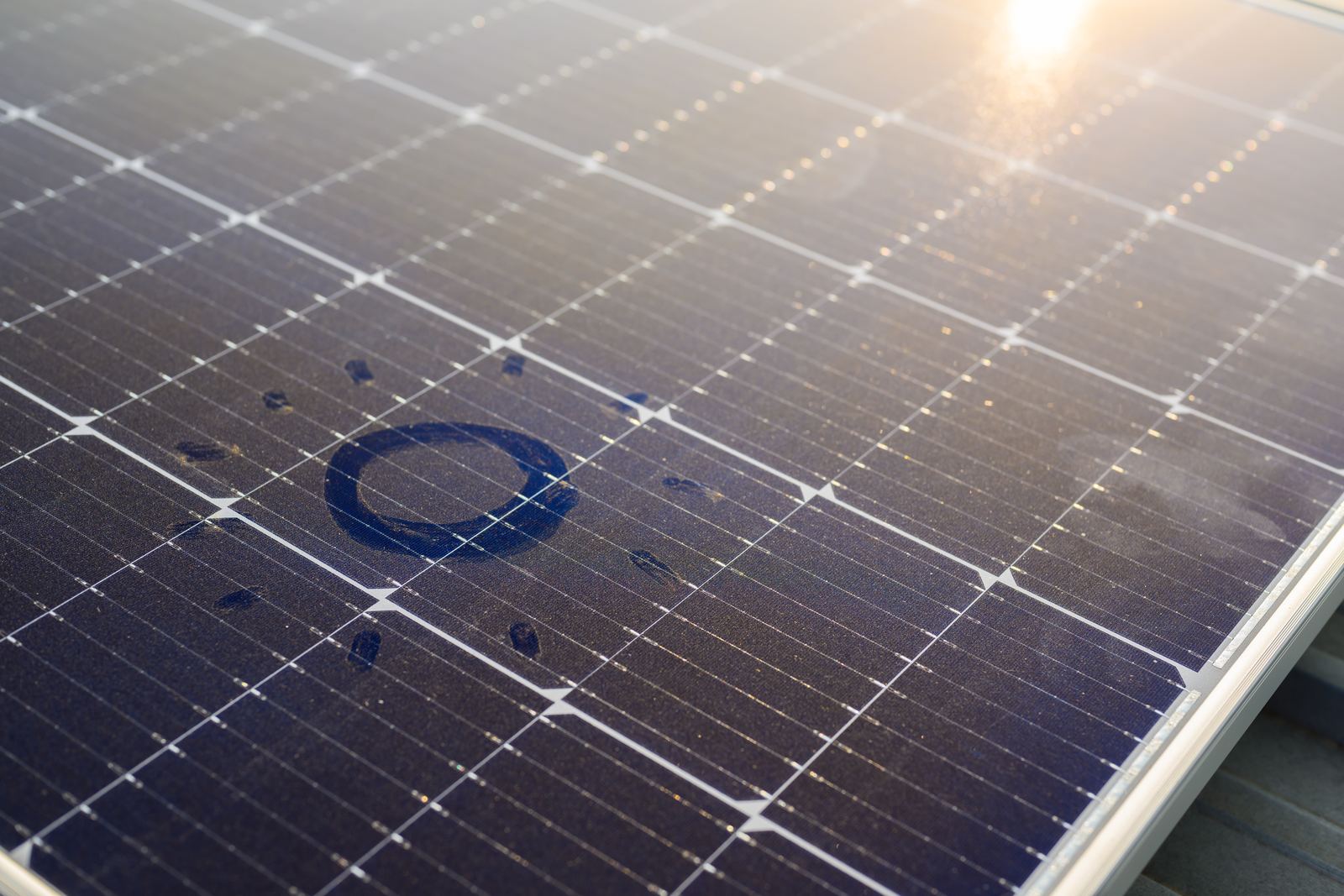 Module photovoltaïque couvert de poussière, éclairé par le soleil
